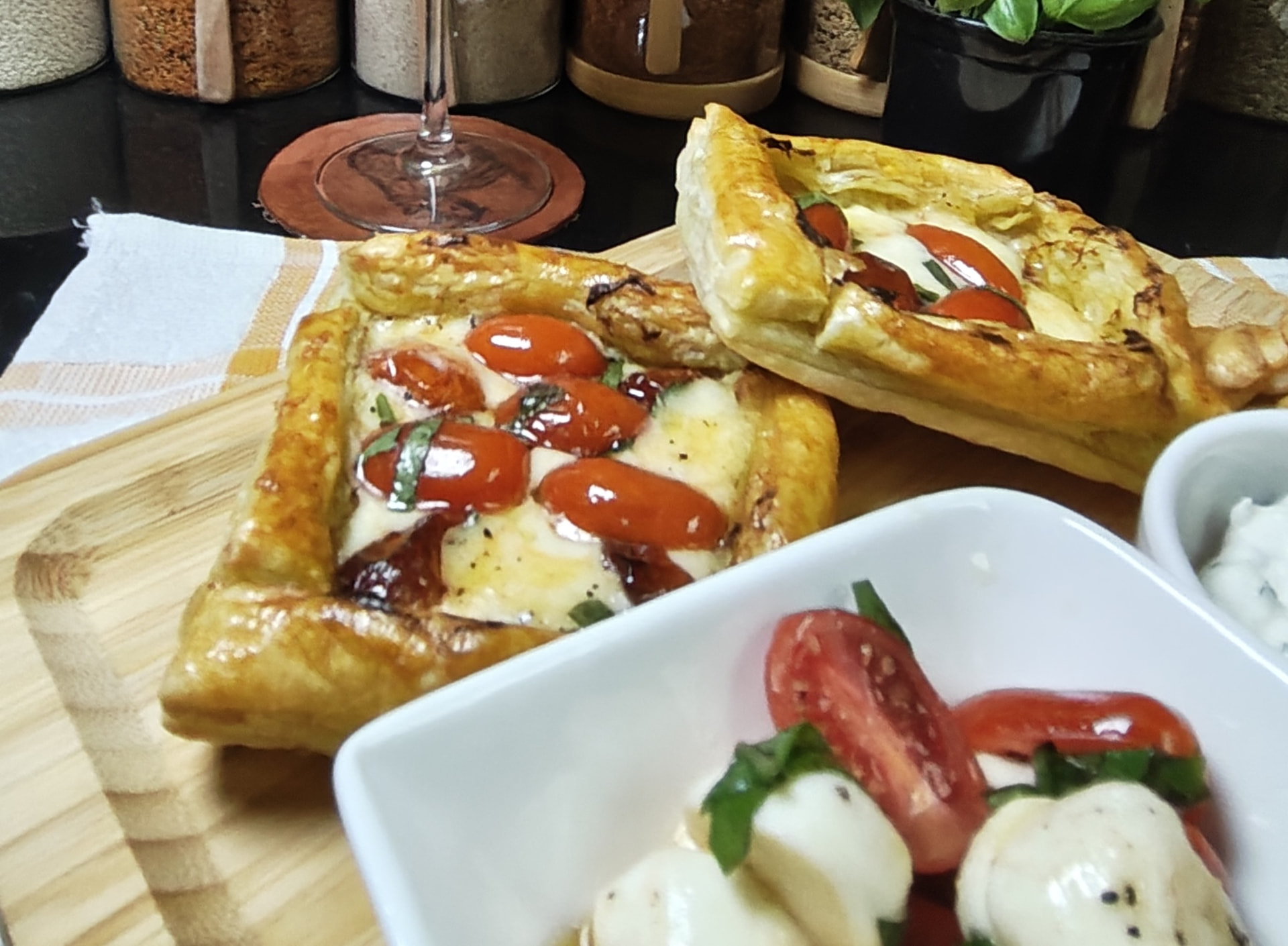 Golden air fryer puff pastries topped with pesto, cherry tomatoes and mozzarella