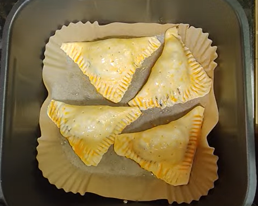 Triangular beef and cheese pastries prepared for air frying