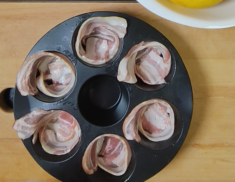 Raw bacon rashers arranged in the cavities of a round silicone mould