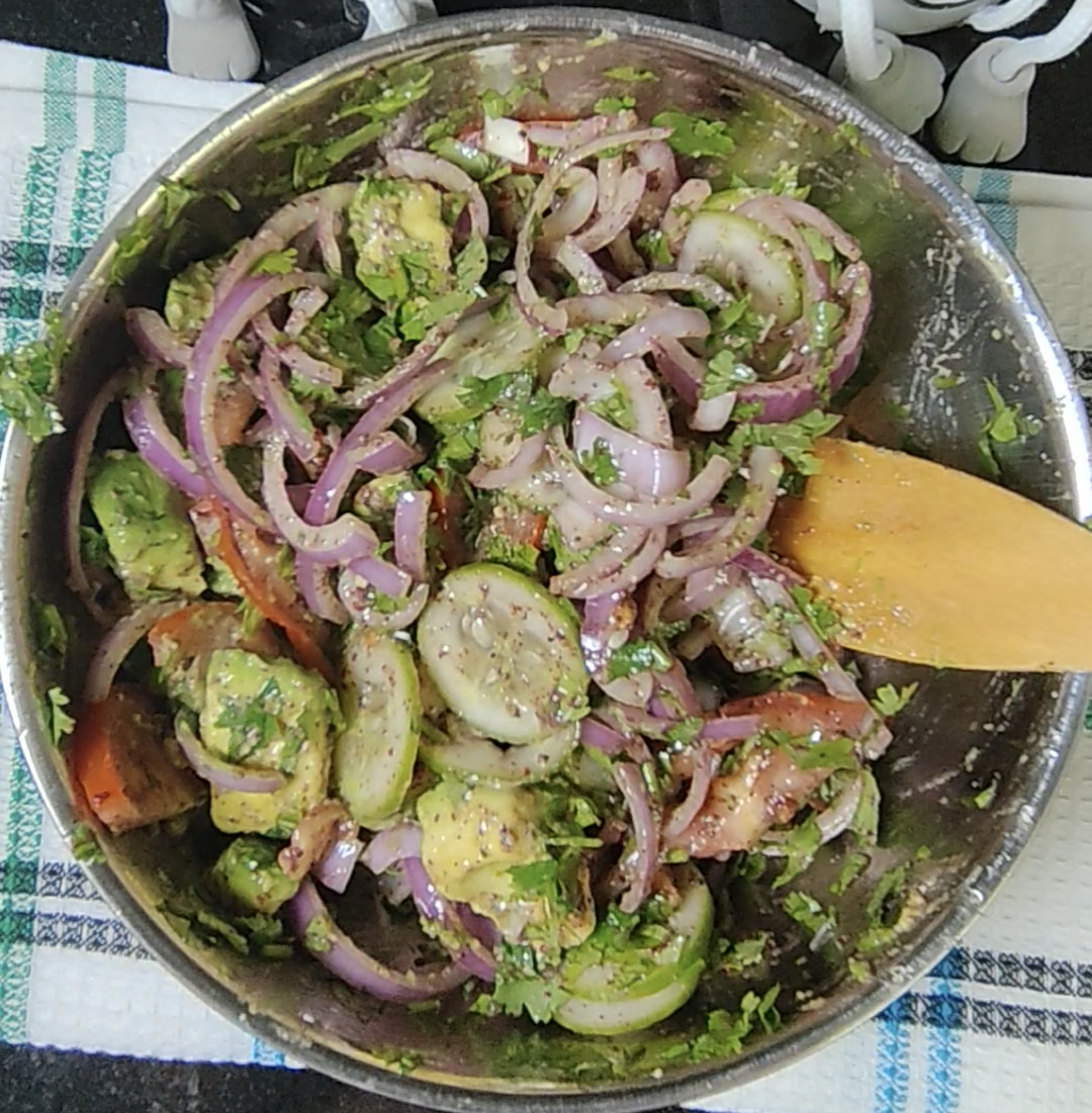 The mixed avocado, cucumber, tomato, red onion and coriander salad in the bowl