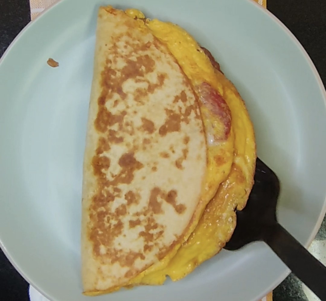 Golden folded tortilla filled with eggs, salami and mozzarella cheese