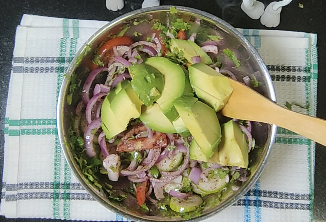 Sliced avocado added to the salad bowl before the final mixing